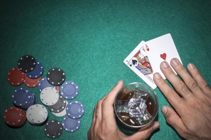 poker-player-showing-jack-ace-card-with-casino-chips-green-poker-table-1